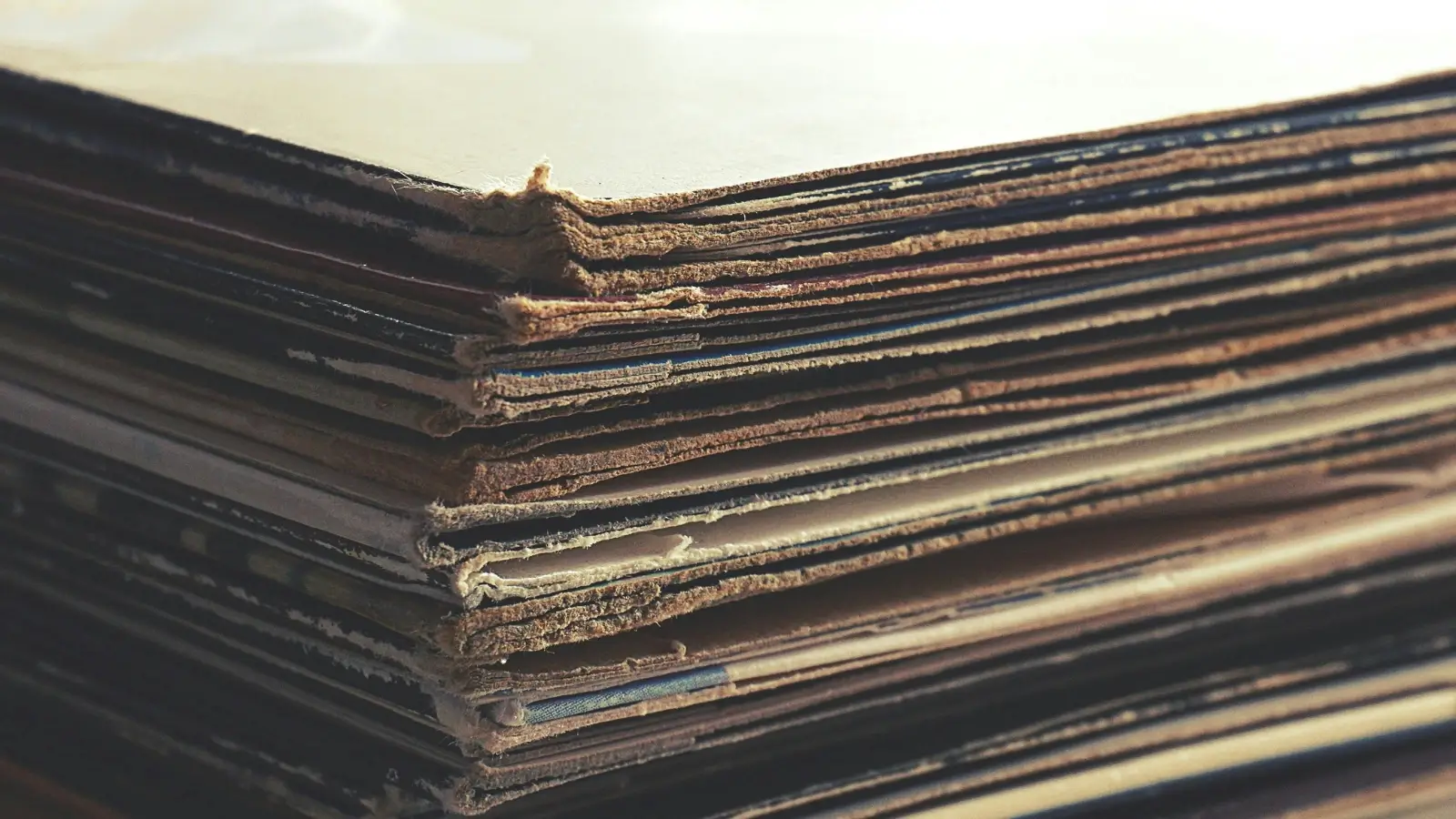 Compact cardboard bales stacked neatly beside a vertical baler in a warehouse