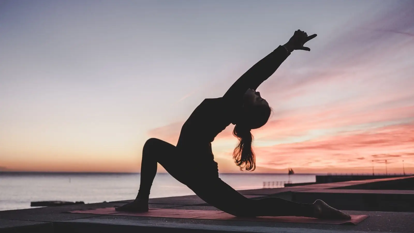 Person stretching at sunrise, symbolizing balanced wellness through lifestyle and internal health