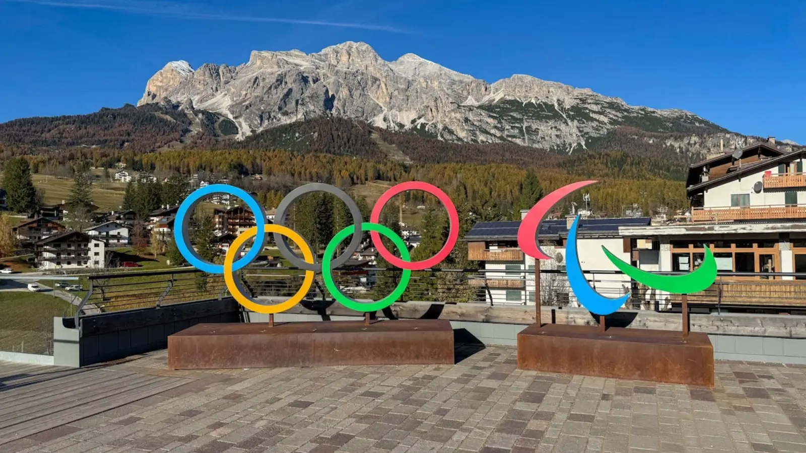 Milan–Cortina 2026 Winter Olympics logo over Alpine scenery with Olympic venues