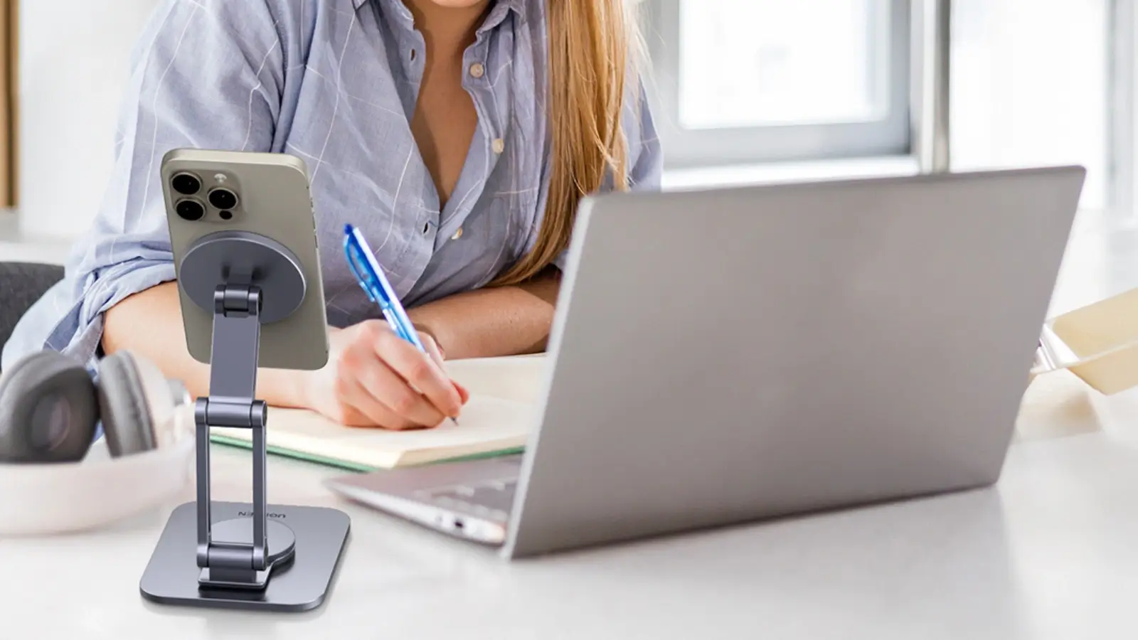 Smartphone wirelessly charging on a MagSafe-compatible charging pad at a desk