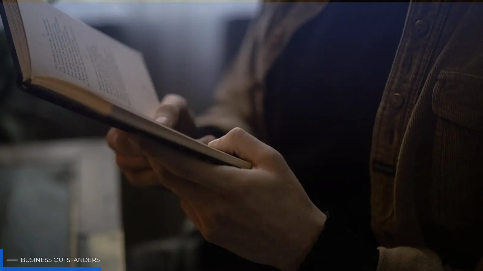 Person reading a book with focused comprehension and understanding