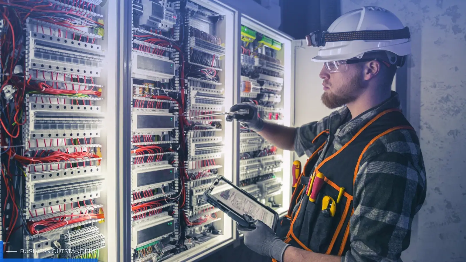 Commercial electrician working on electrical panel in modern office building