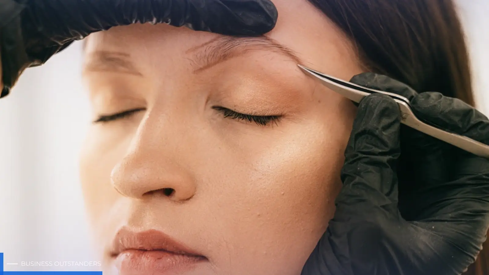 Professional technician performing eyebrow embroidery on a client for natural-looking defined brows