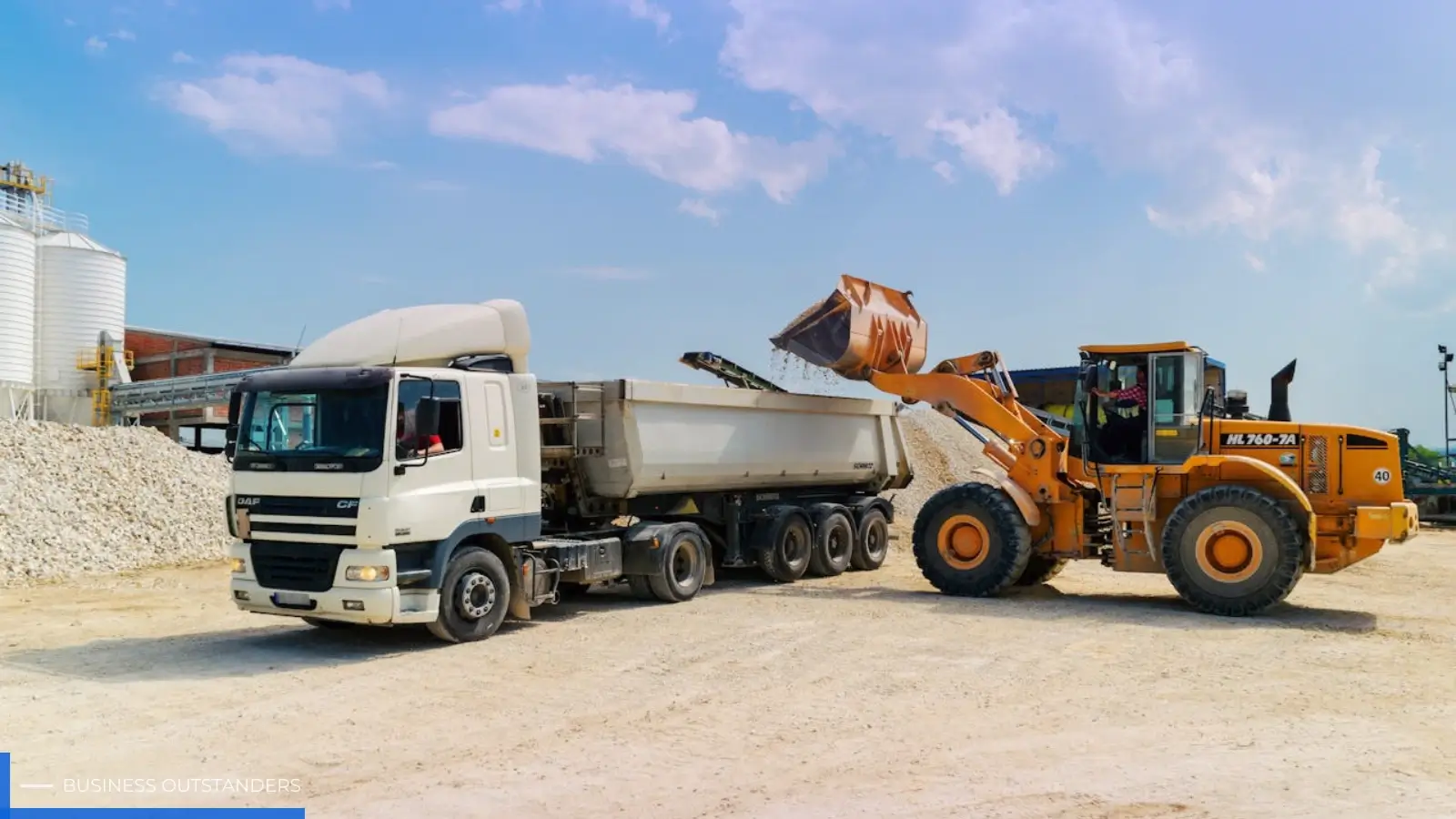 A heavy-duty work truck loaded with construction equipment on a job site