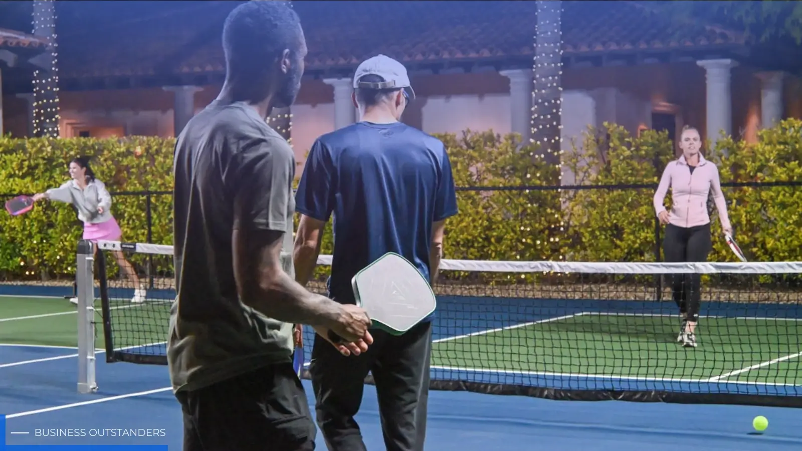 Guests playing pickleball on a sunny resort court in Mexico with palm trees in the background