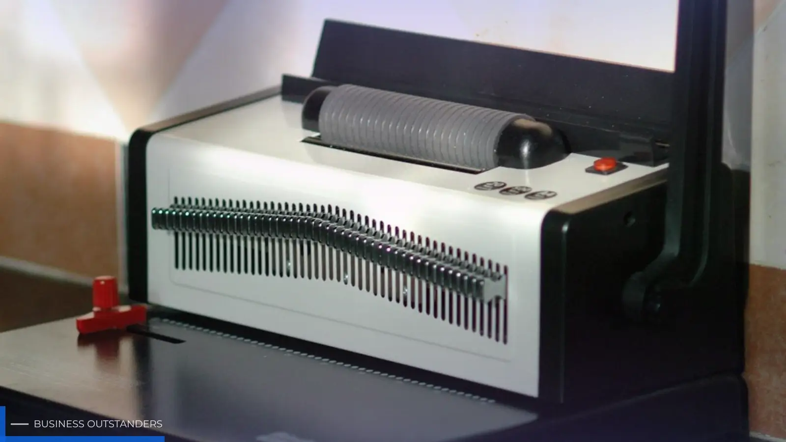 Office binding machine neatly binding stacked documents into a professional booklet