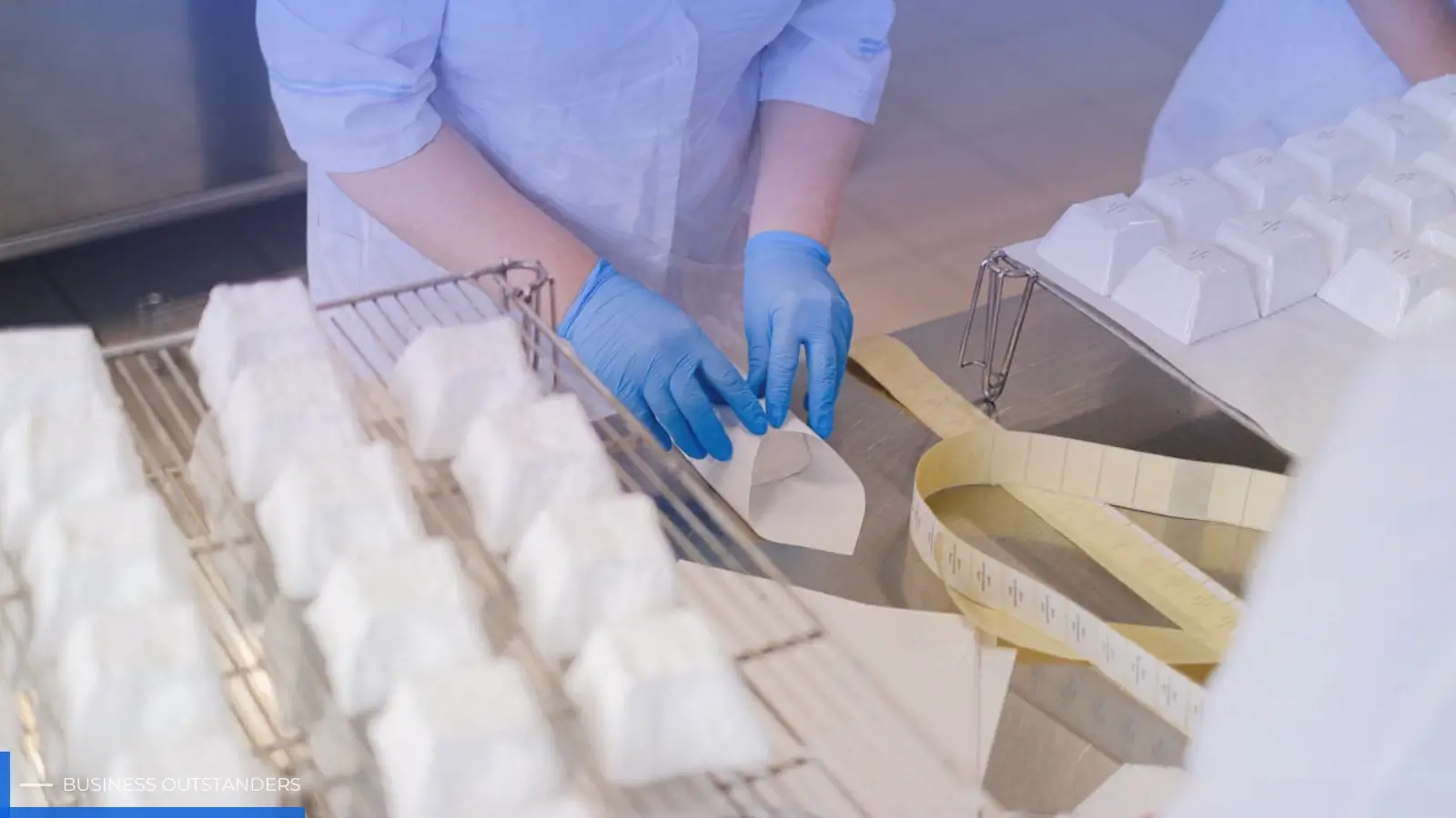 Worker inspecting product labels on a high-speed manufacturing production line for quality control