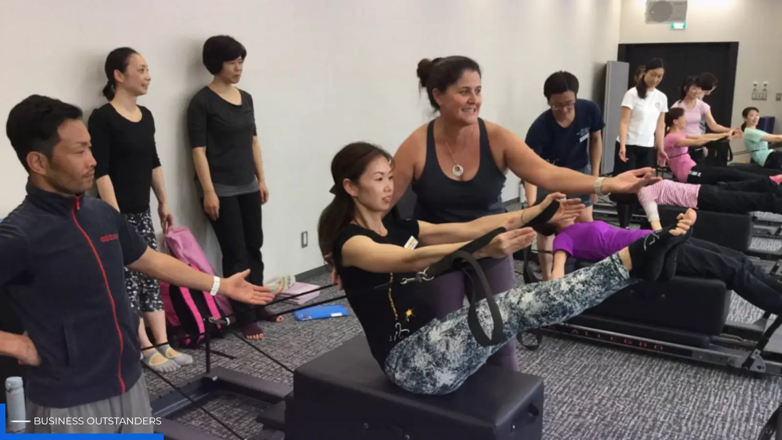 Pilates instructor guiding a client through movement exercises during a training session