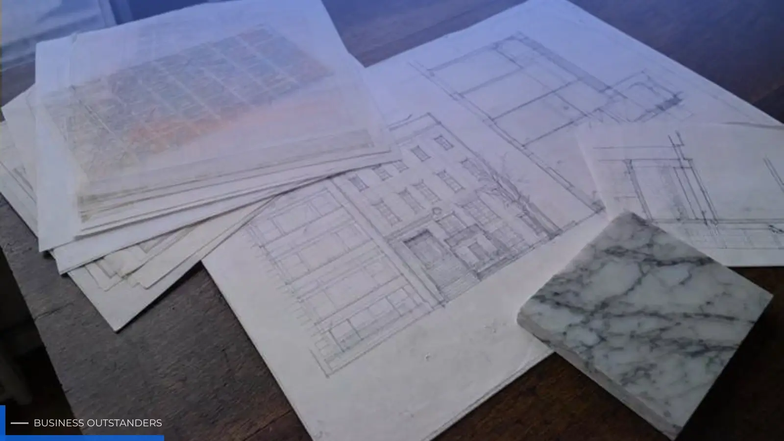 Architect reviewing luxury home floor plans and material samples at a kitchen island in a high-end New York residence