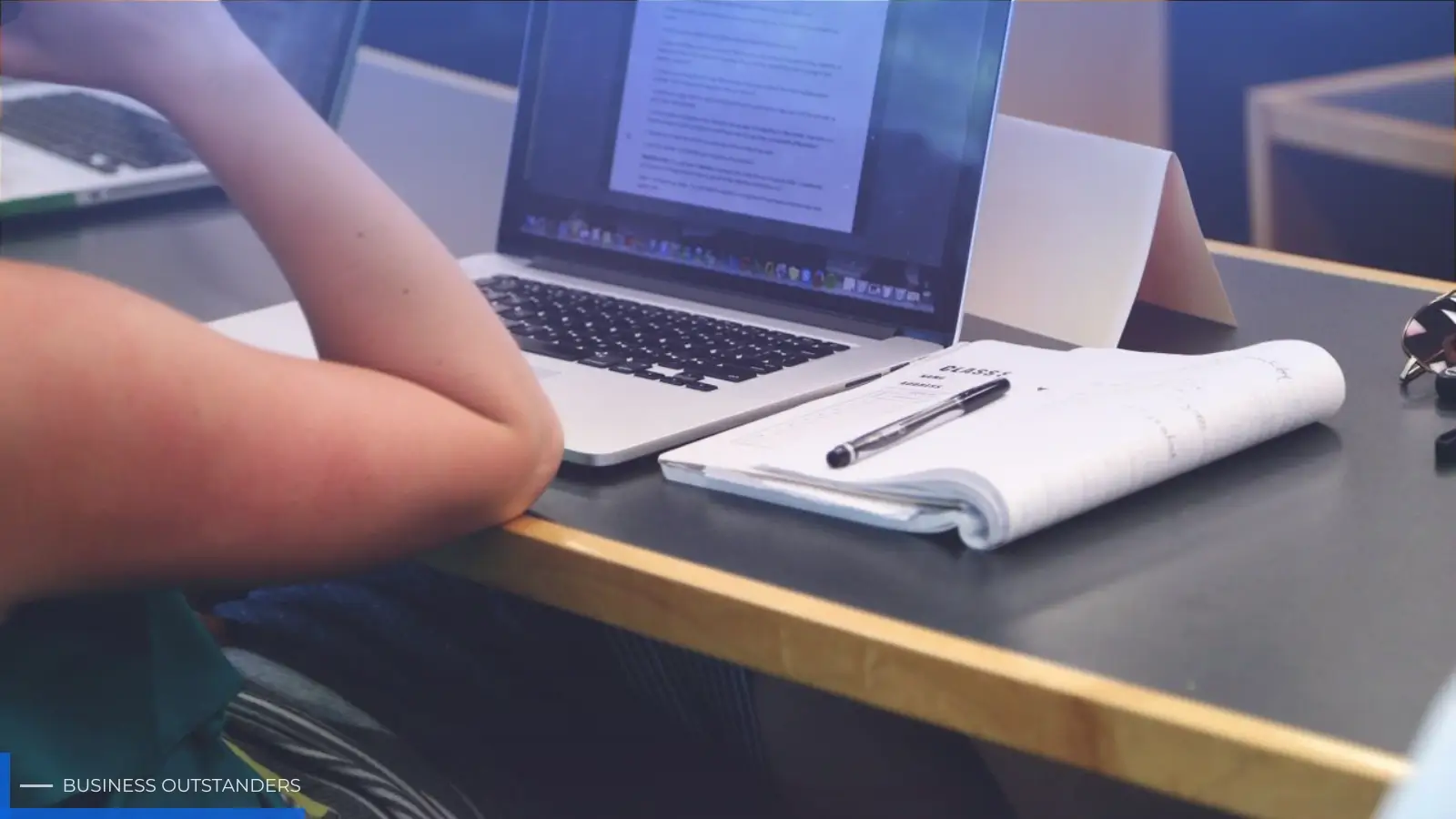A student studying for the CompTIA A+ certification with IT hardware components and a laptop on a desk