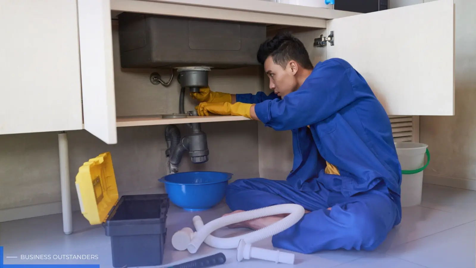 A plumber fixing a burst pipe during a home plumbing emergency