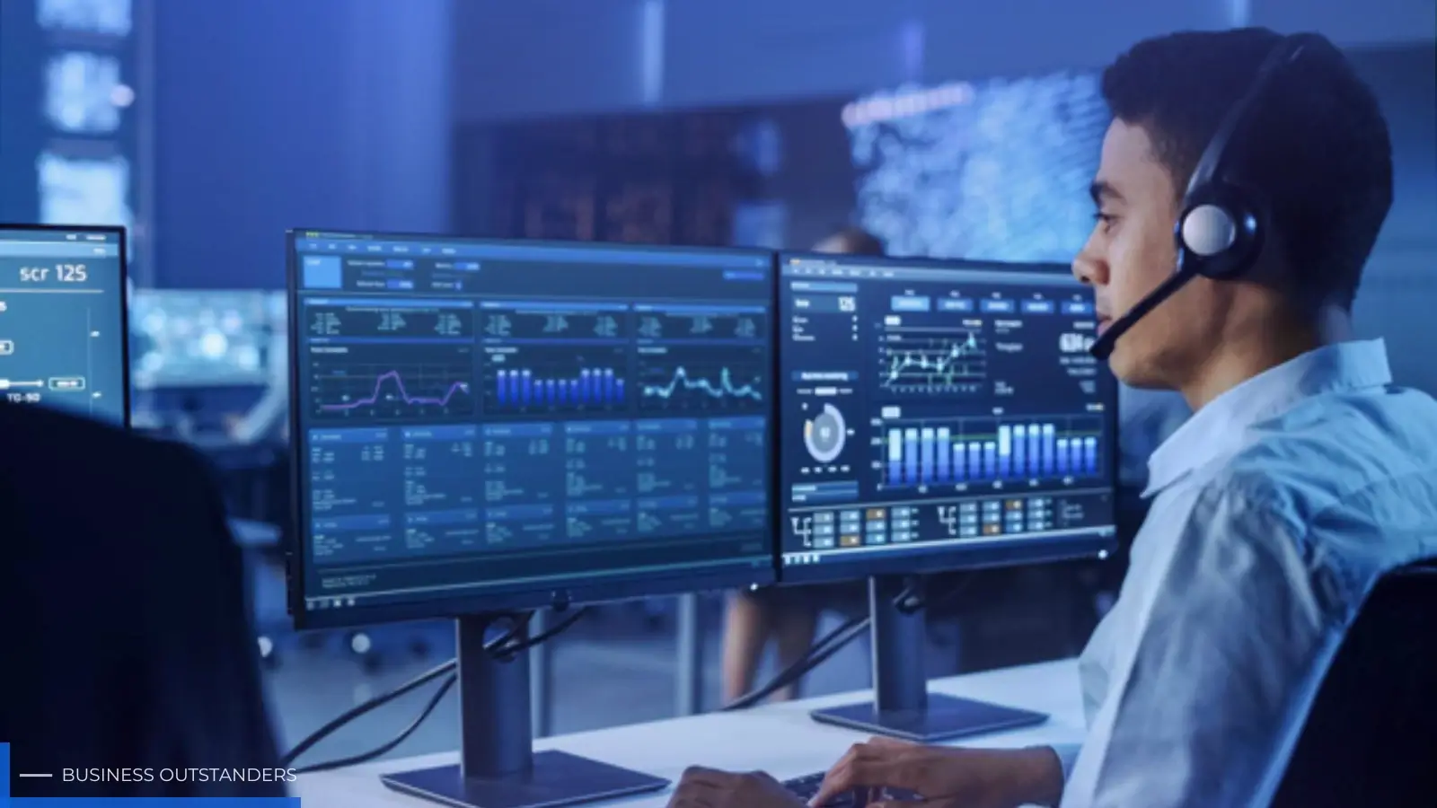 IT professional monitoring business network systems on multiple screens for managed service provider support