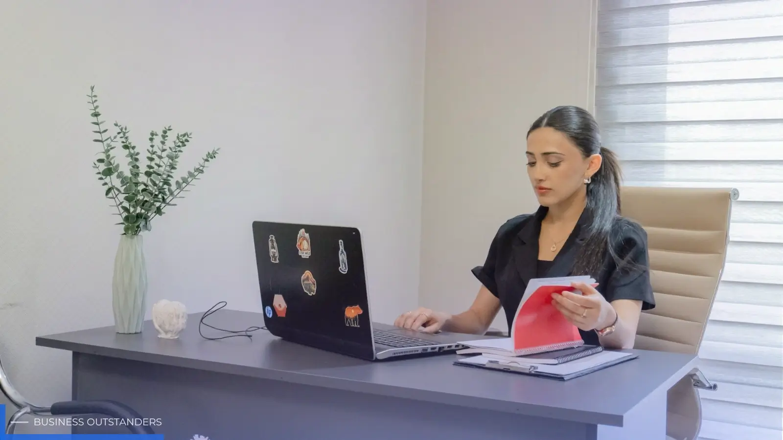HR professional reviewing workplace accommodation documentation files at office desk